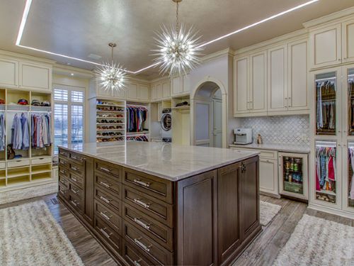 luxury walk-in closet with contemporary lights