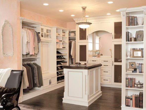 luxury walk-in closet with painted wood cabinets